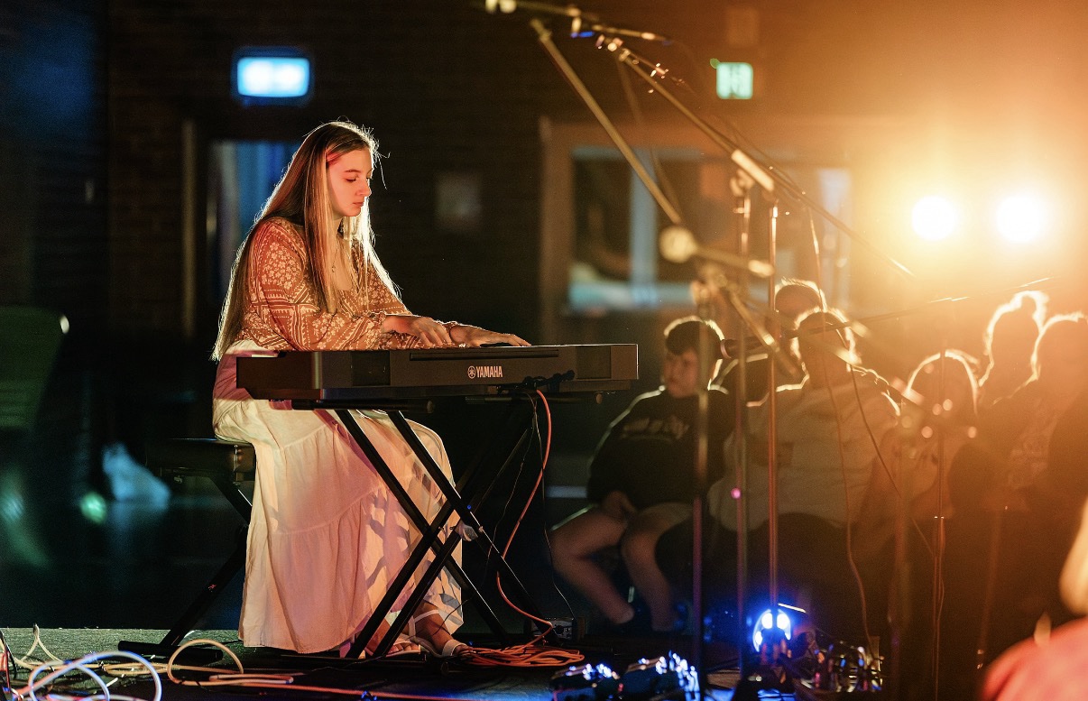 A pianist performing under warm stage lighting