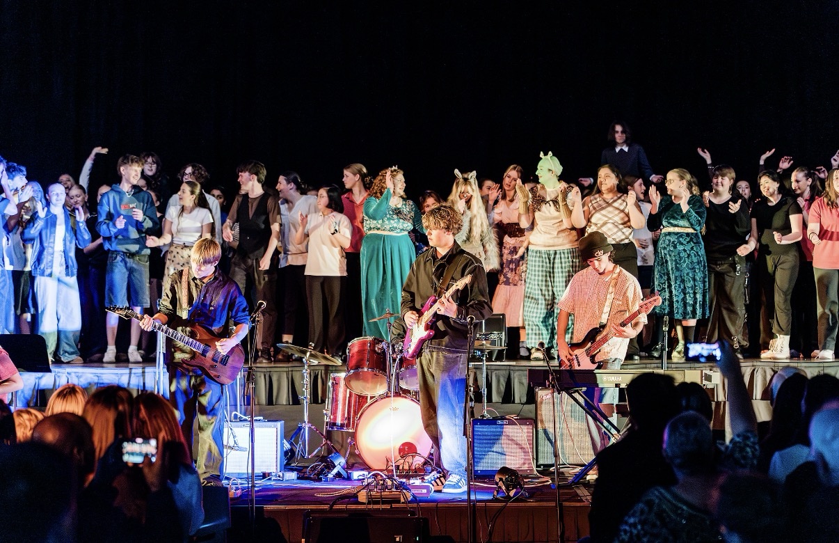 A College performance with musicians, a full stage and an audience